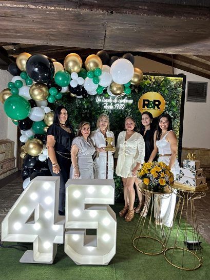 El equipo de la agencia en la celebración de sus 45 años, junto a un aviso que dice Un legado de confianza desde 1980.
